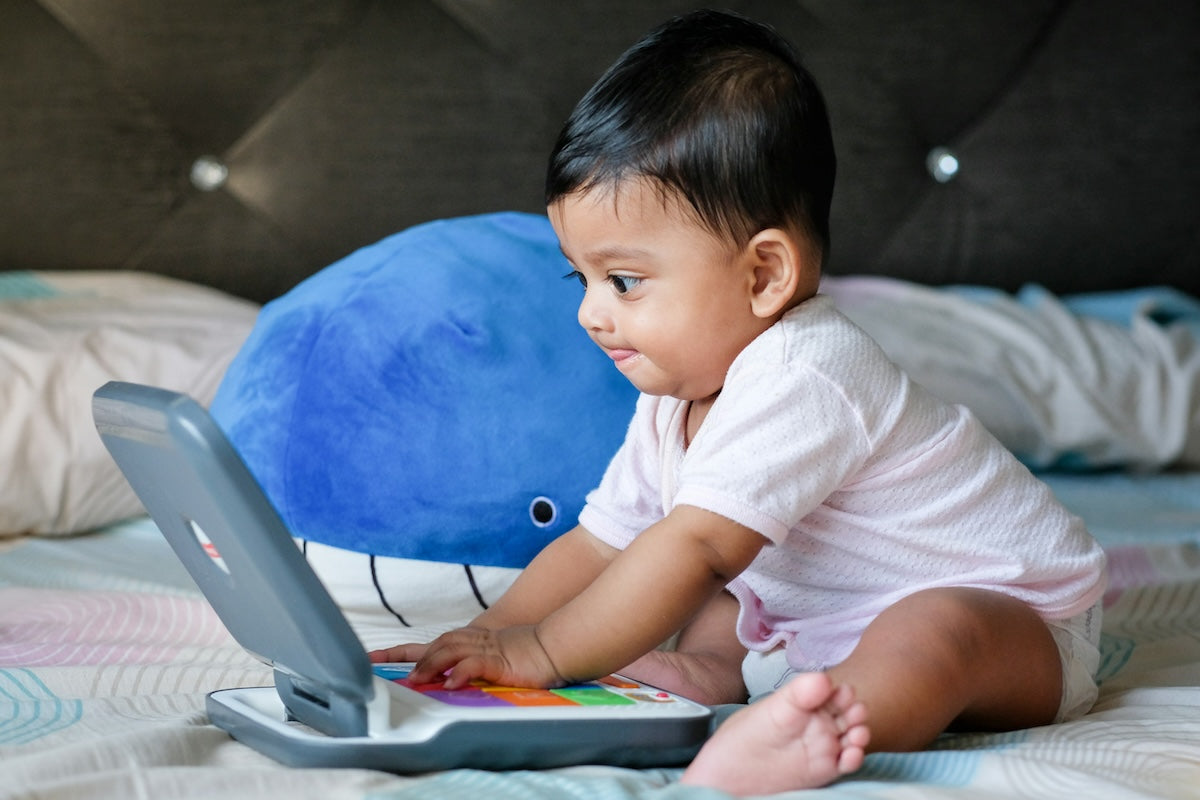 Baby using a toy laptop
