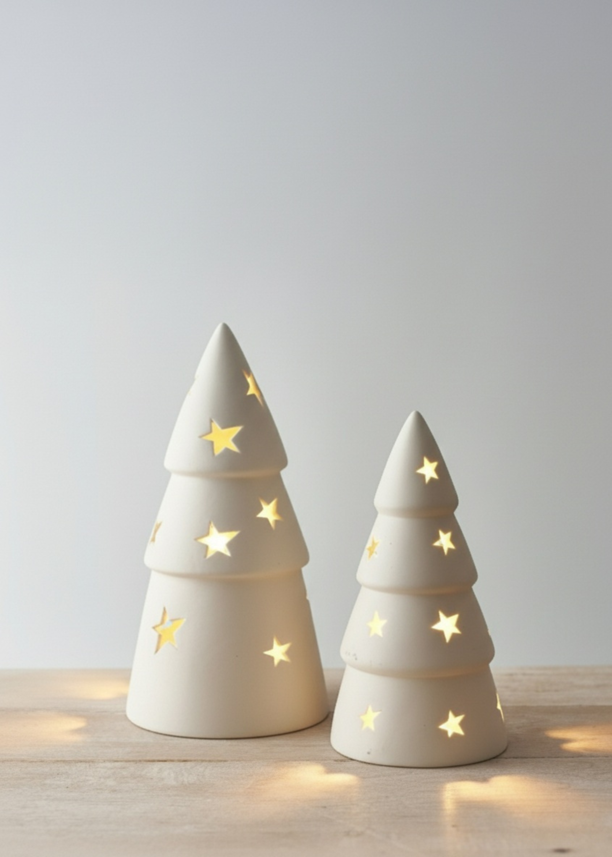Truly Lifestlye White Two ceramic Christmas tree lights with star decorations on a wooden surface.