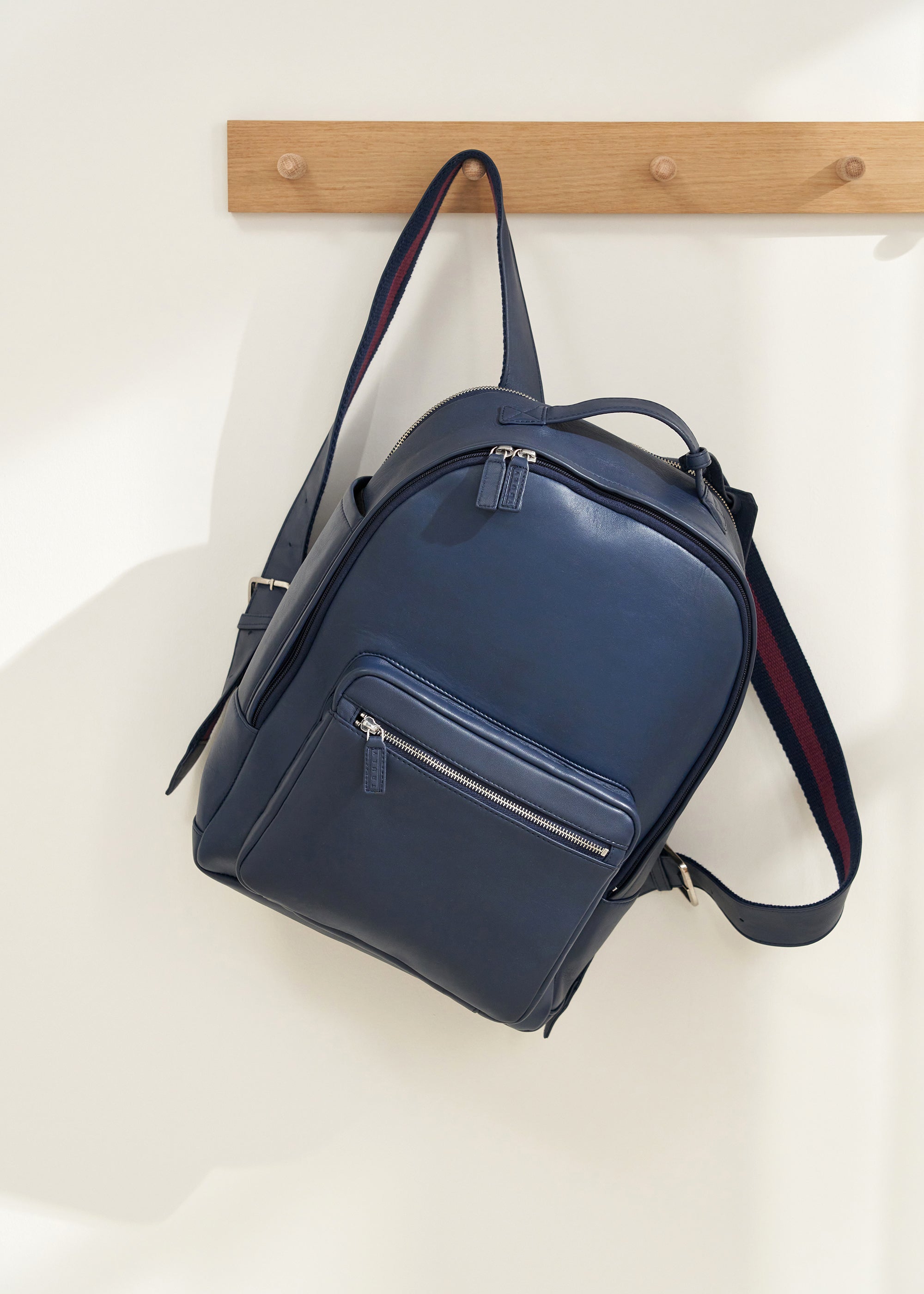 TRULY LIFESTYLE NAVY LEATHER UNISEX BACKPACK HANGING ON A PEG