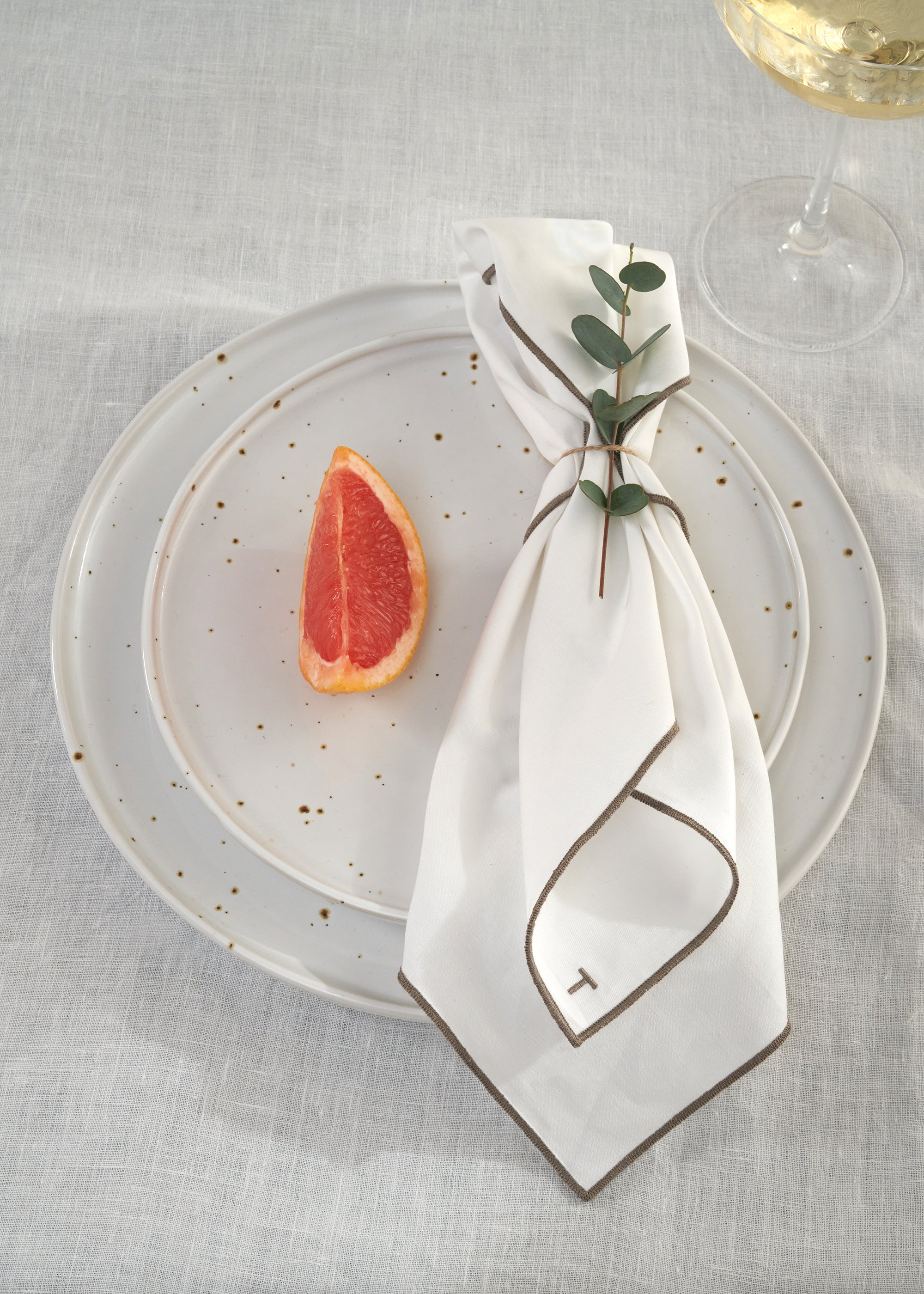 TRULY LIFESTYLE EMBROIDERED EGDE WHITE NAPKIN ON PLATE