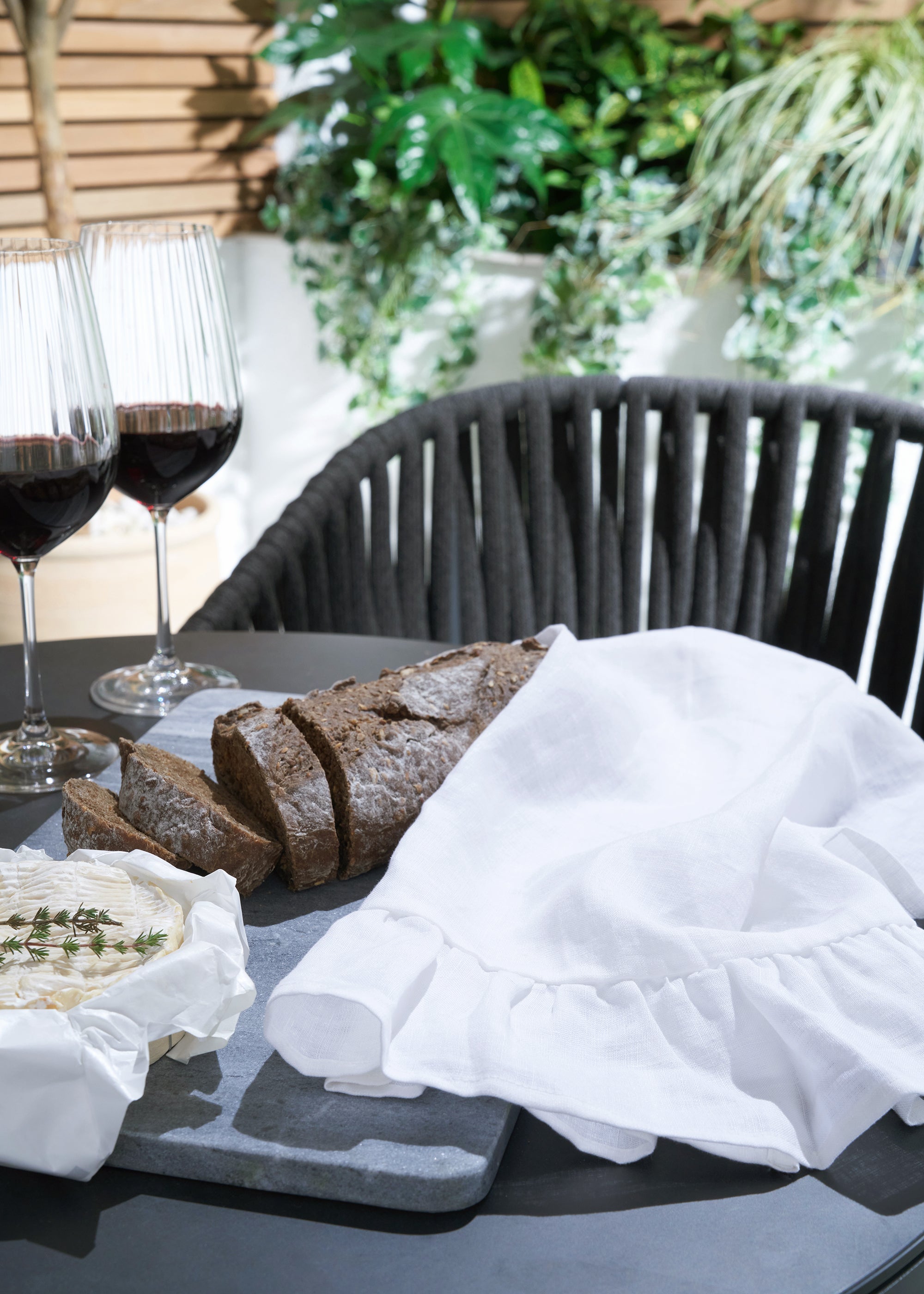 truly lifestyle white linen tea towel
on garden table with brea