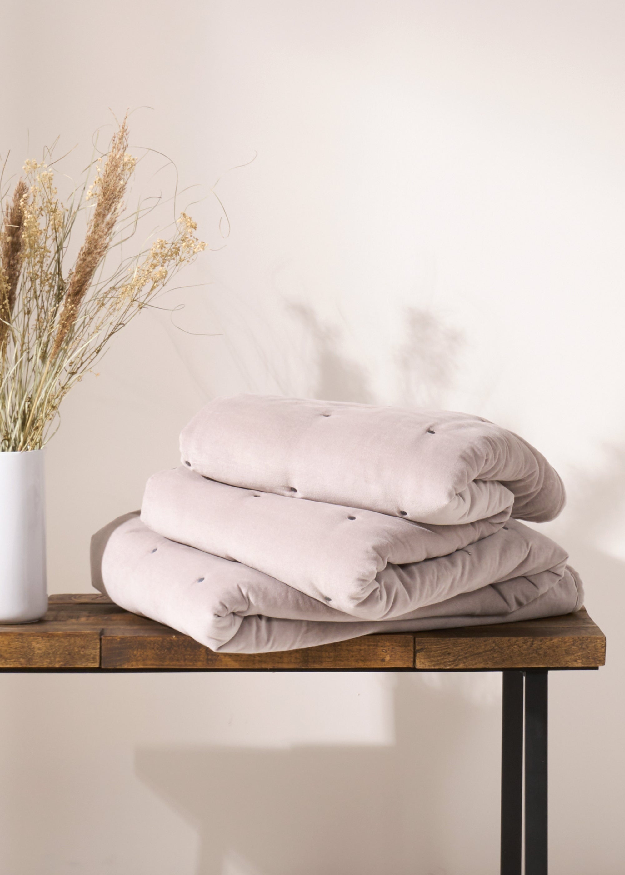 TRULY LIFESTYLE GREY QUILTED EIDERDOWN FOLDED ON A BENCH