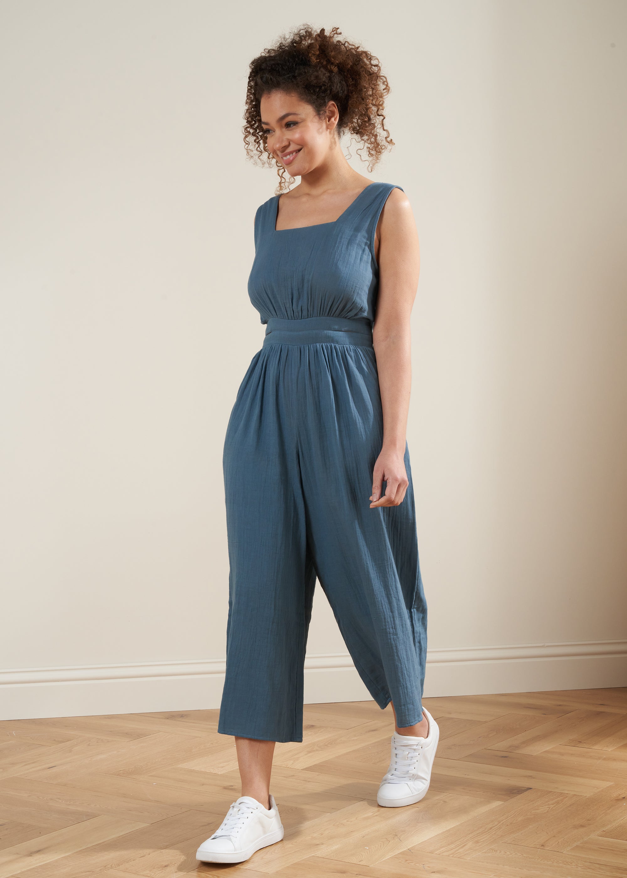 TRULY LIFESTYLE BLUE WOMENS COTTON CHEESECLOTH JUMPSUIT ON MODEL WITH TRAINERS