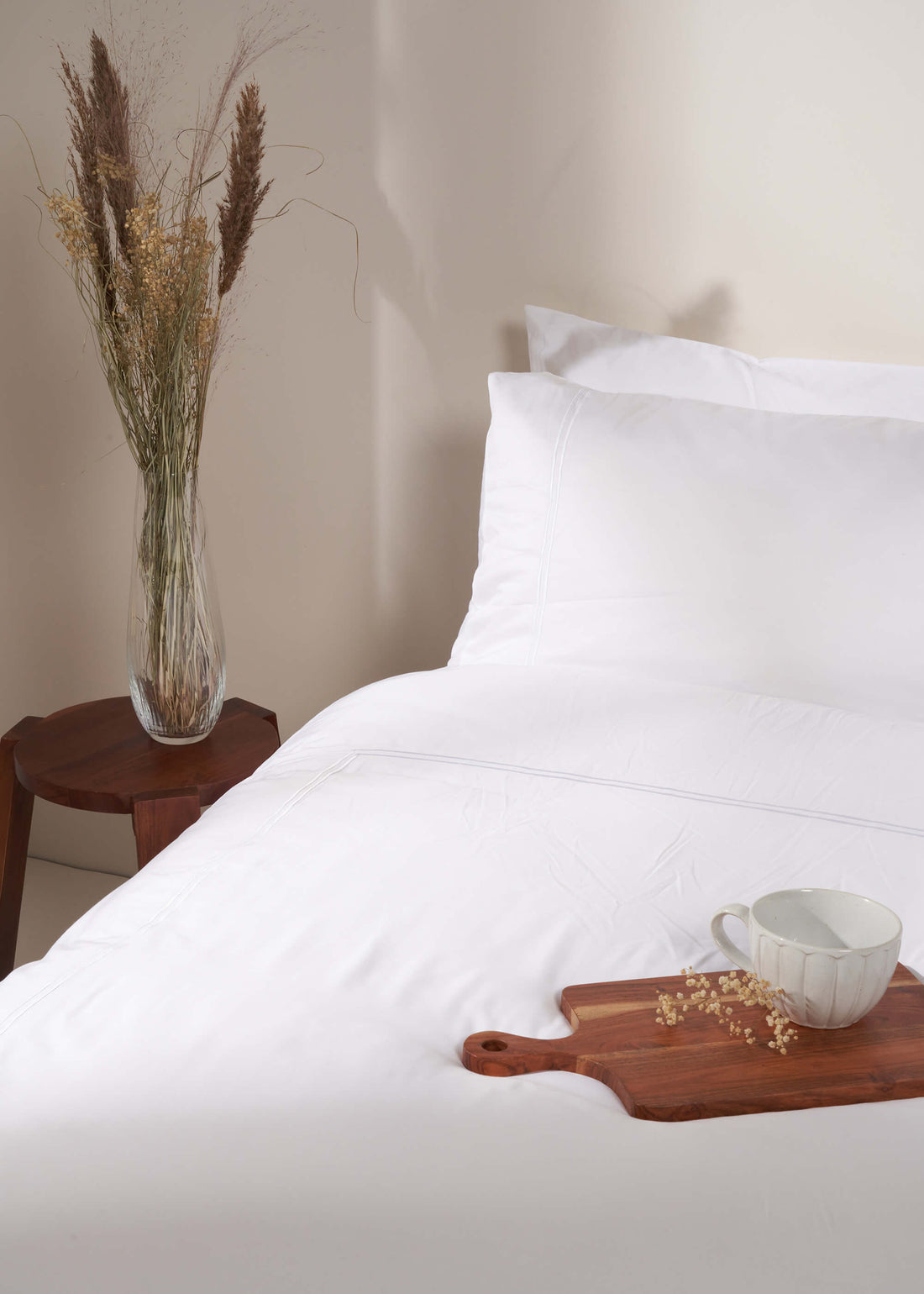 TRULY LIFESTYLE WHITE SATIN STITCH BAMBOO DUVET ON BED WITH DRIED FLOWERS IN A CRYSTAL VASE