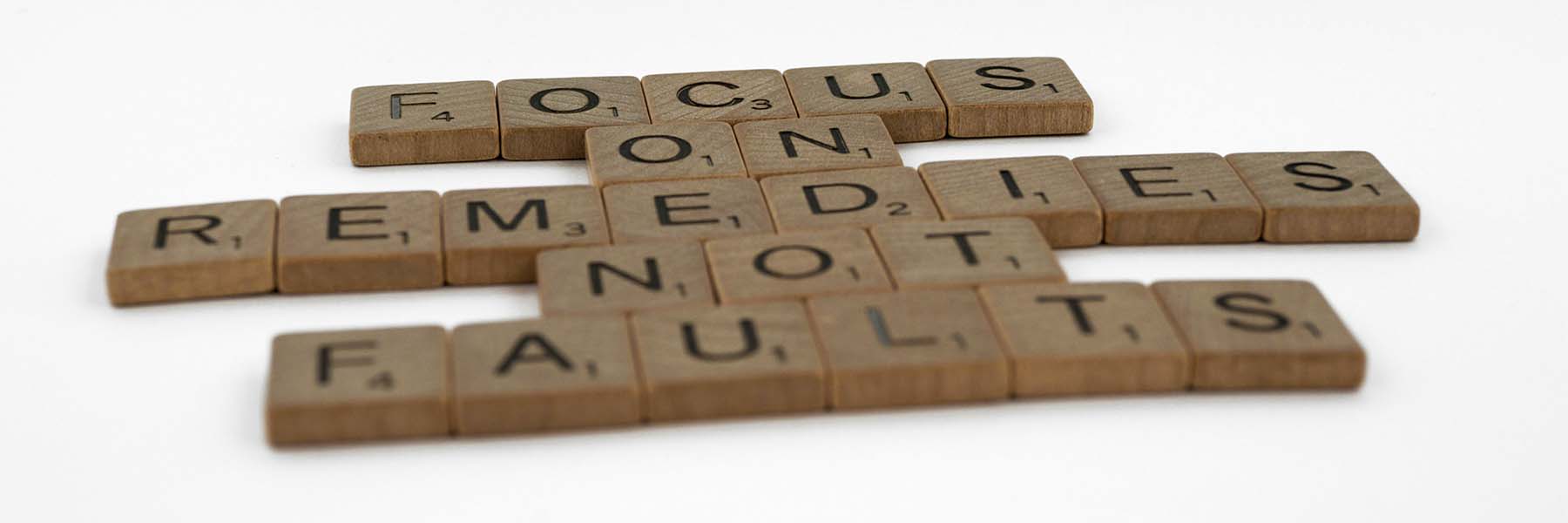 Scrabble tiles saying to focus on solutions not fault to stop self doubt 