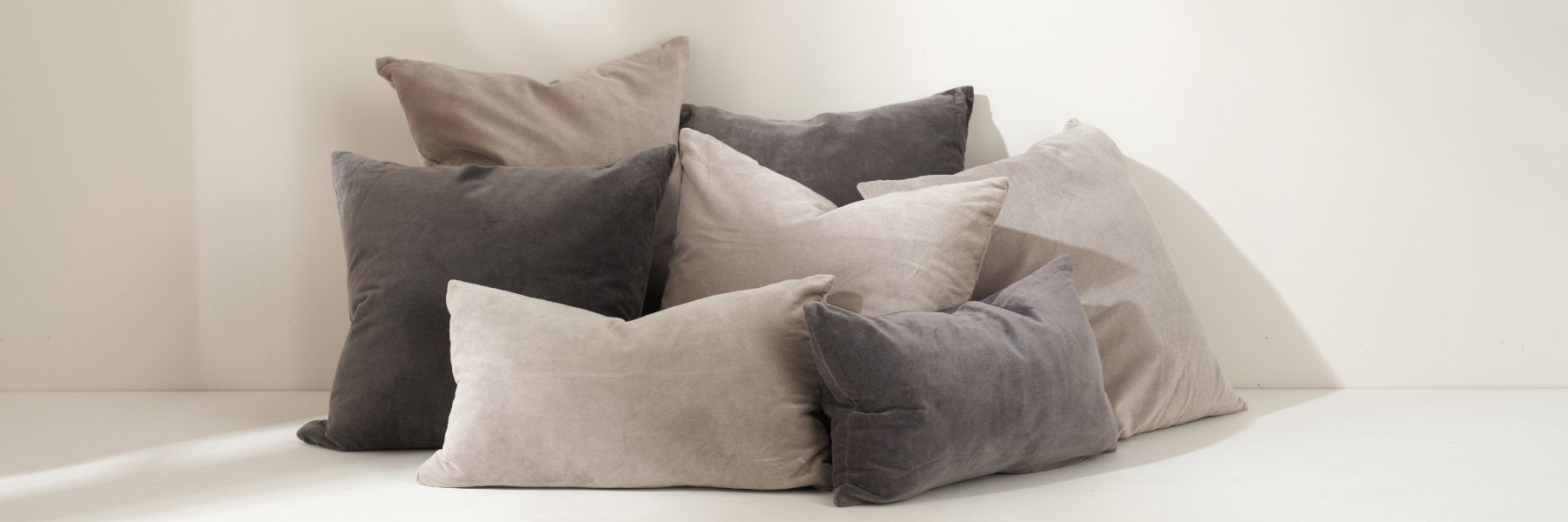 Truly Lifestyle All Living Banner With Grey And Charcoal Velvet Cushions In A Pile