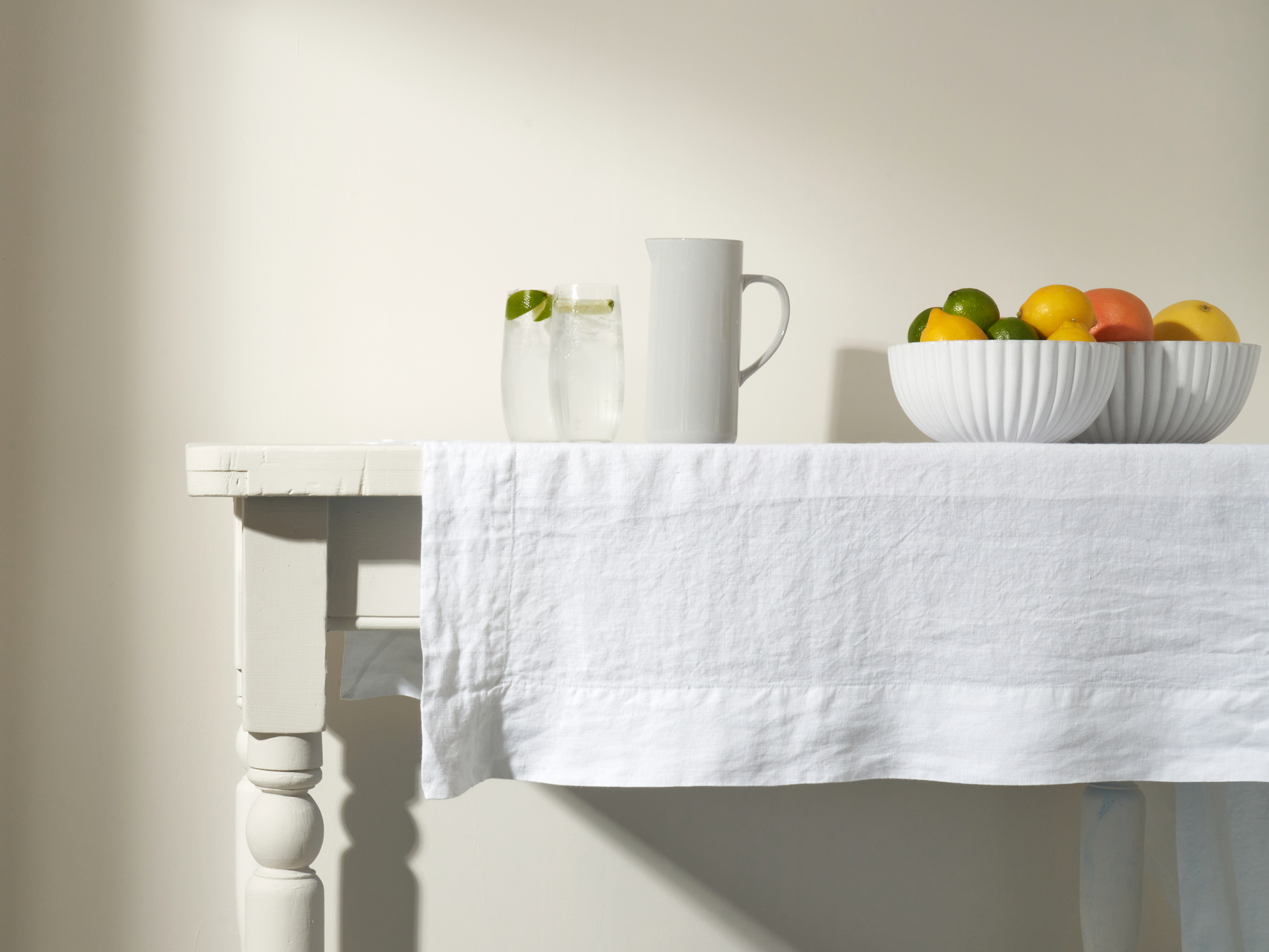Truly white linen table cloth. Fluted white serving bowls and hi ball glasses