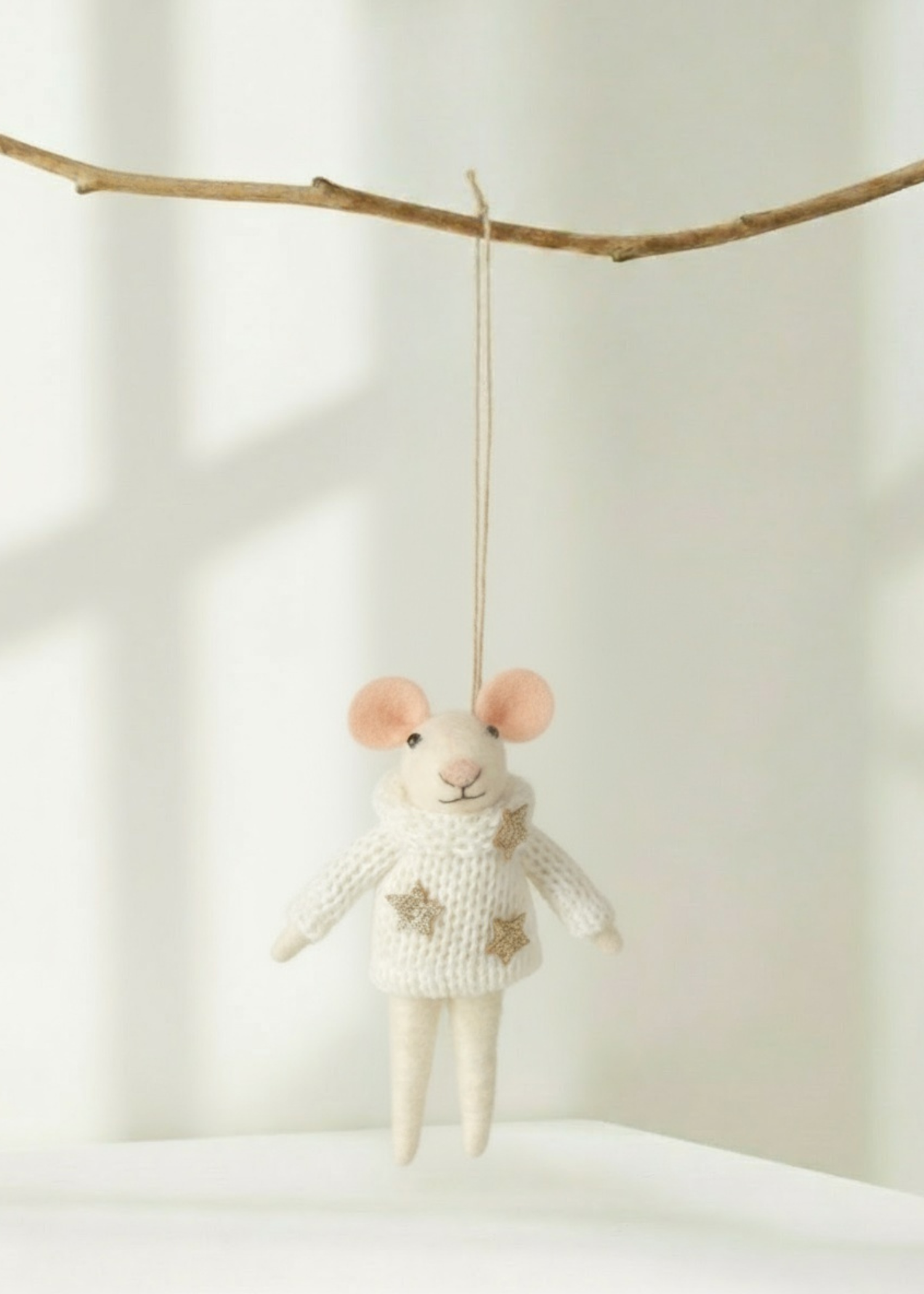 Truly Lifestyle Christmas Knitted mouse decoration changing from a branch on a light background