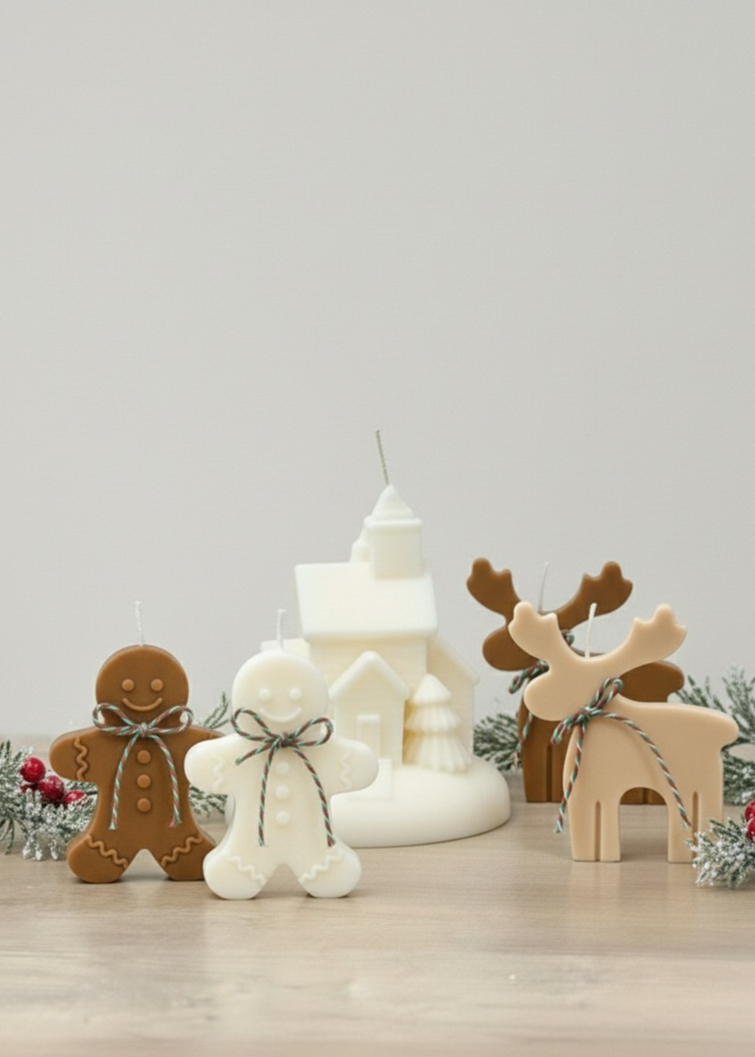 Truly Lifestyle Decorative candles shaped like a gingerbread man, snowman, and reindeer on a light surface with a neutral background.