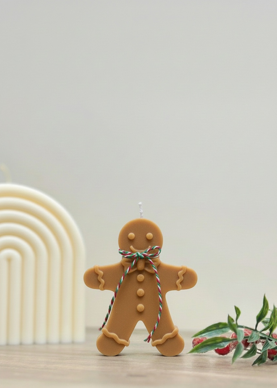 Truly Lifestyle Gingerbread man candle with a decorative bow on a neutral background