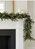 Truly Lifestyle Christmas Greenery and red berry garland on a white fireplace mantel.