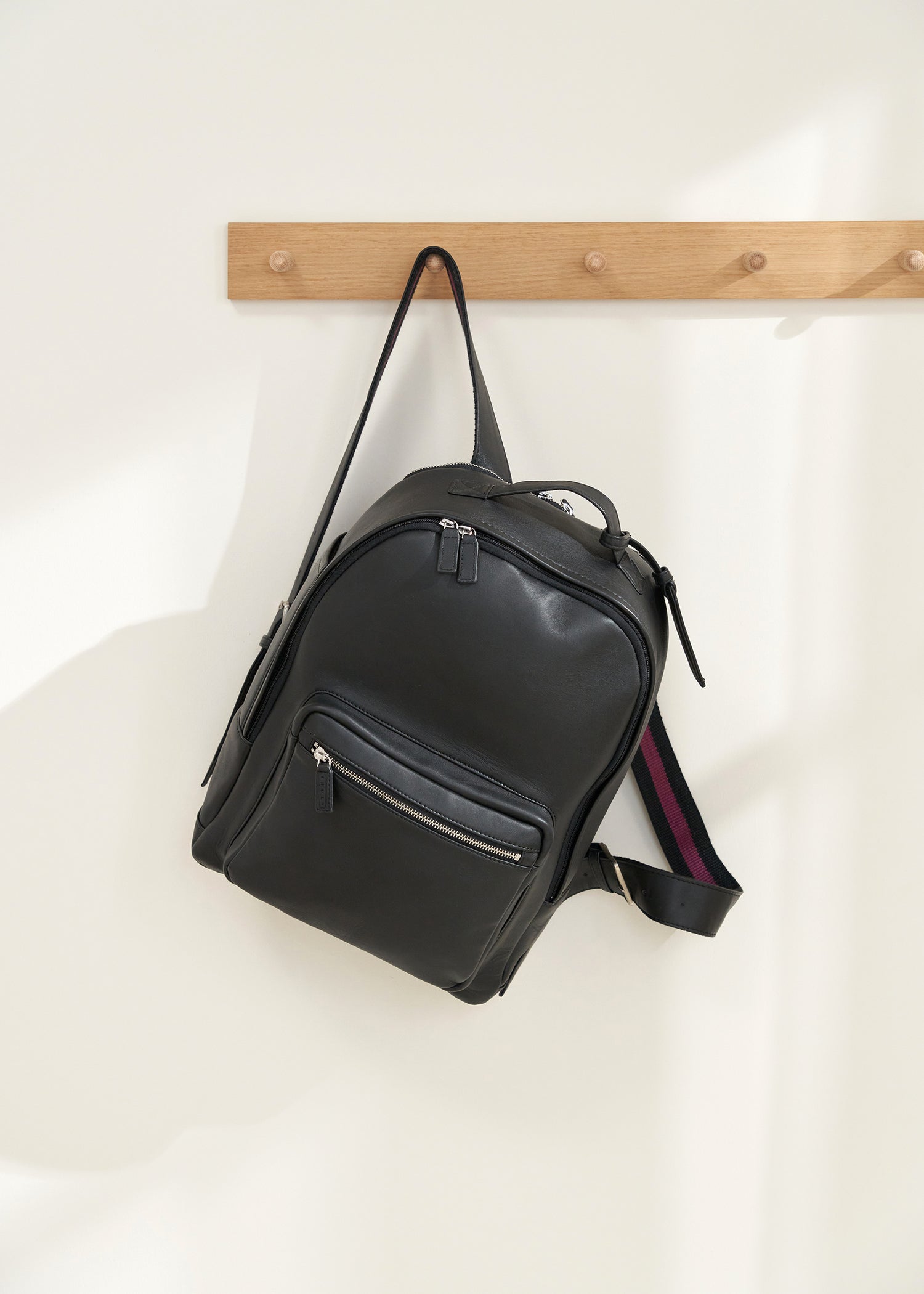 TRULY LIFESTYLE BLACK UNISEX LEATHER BACKPACK HANGING UP ON PEG