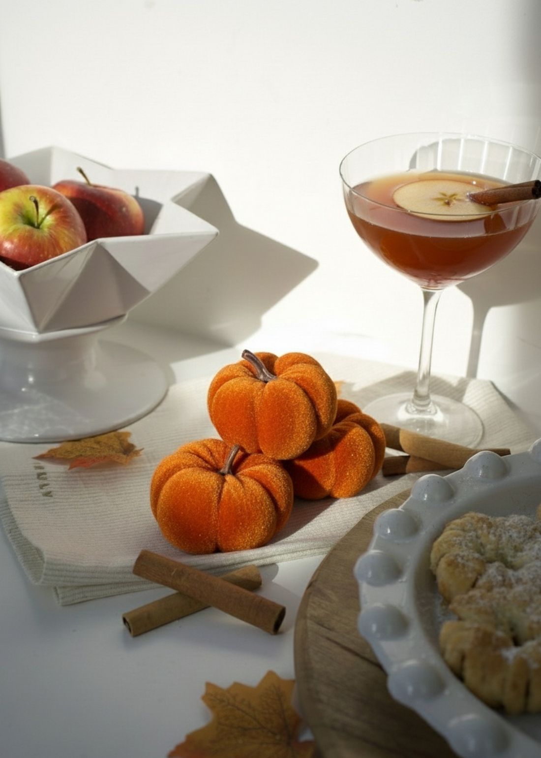 Autumn-themed table setting with pumpkins, apples, and a cocktail by Truly Lifestyle.