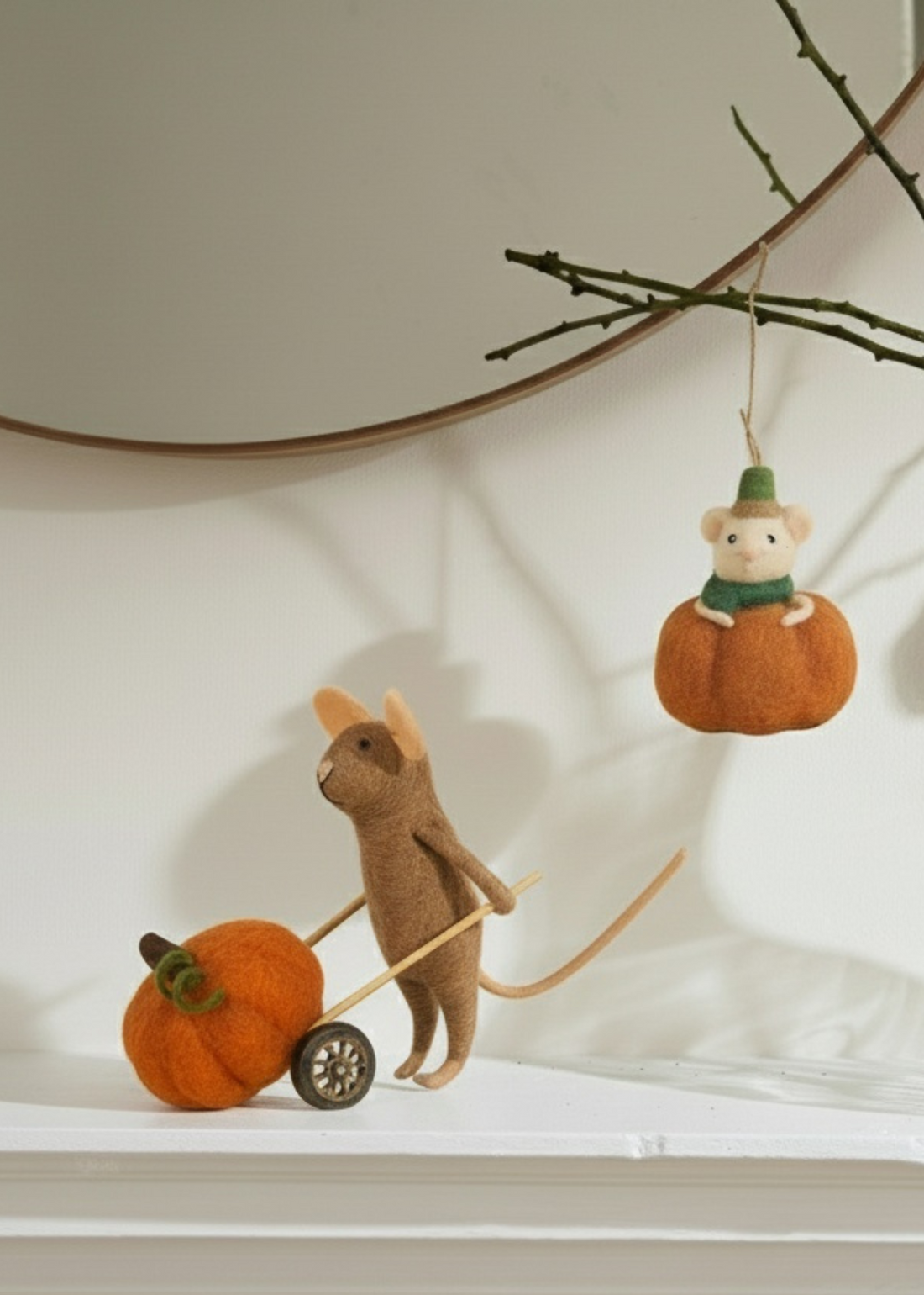Stuffed mouse pulling a cart with pumpkins and another mouse on a pumpkin hanging above by Truly Lifestyle.