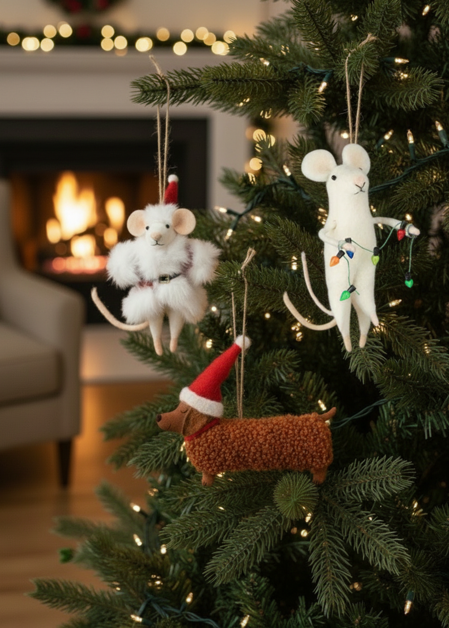 Decorative mouse ornaments on a Christmas tree with a fireplace in the background