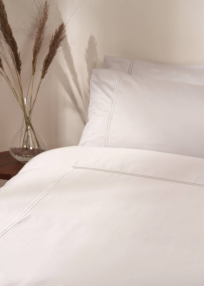 TRULY LIFESTYLE DOVE GREY SATIN STITCH BAMBOO DUVET COVER ON BED WITH PILLOWCASES AND DRIED FLOWERS IN CRYSTAL VASE