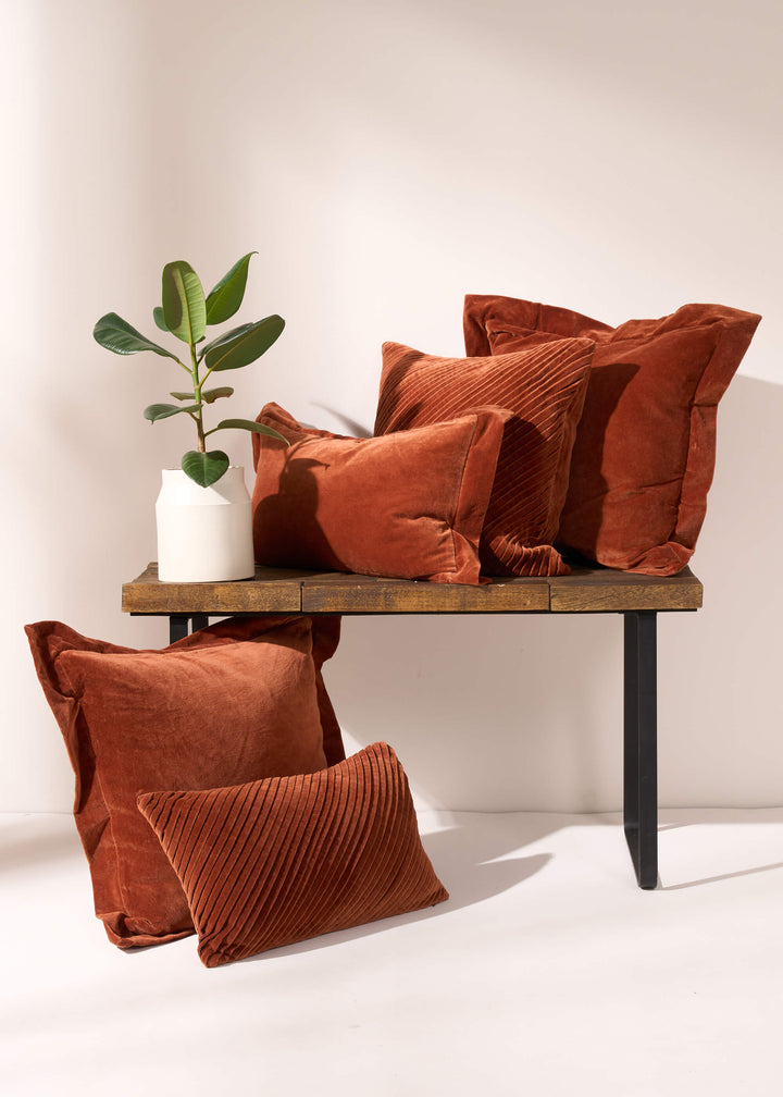 TRULY LIFESTYLE COLLECTION IMAGE OF BURNT ORANGE VELVET CUSHIONS ON A BENCH