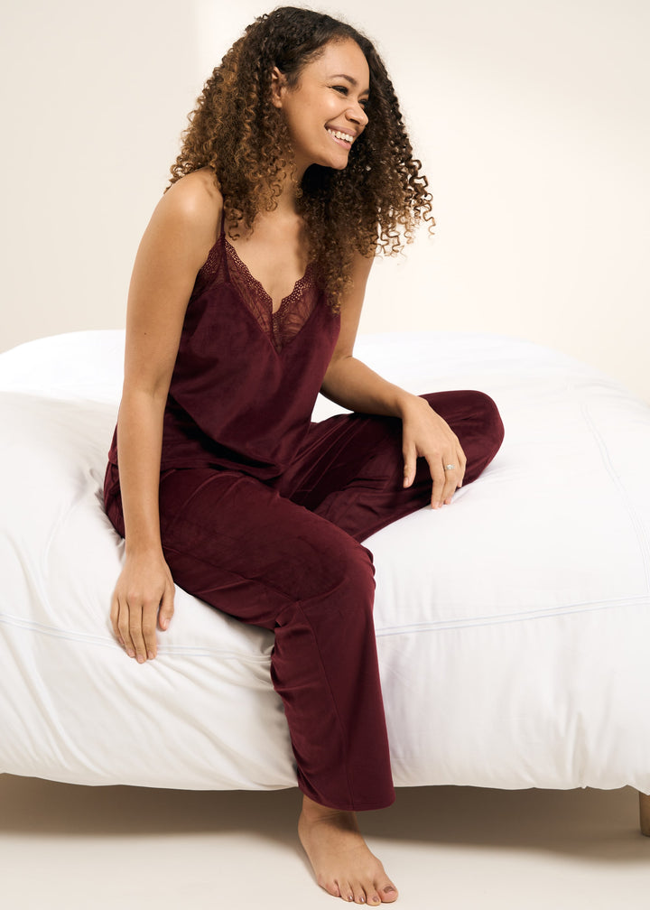Truly Lifestyle Red Berry Velour Womens Pyjama Set On Model Sitting On A Bed