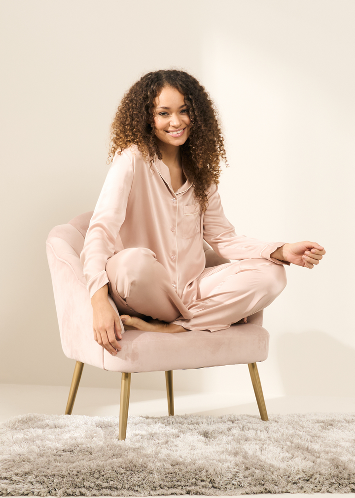 Truly Lifestyle Blush Pink Silk Pyjama Set On Model Sitting On Pink Chair