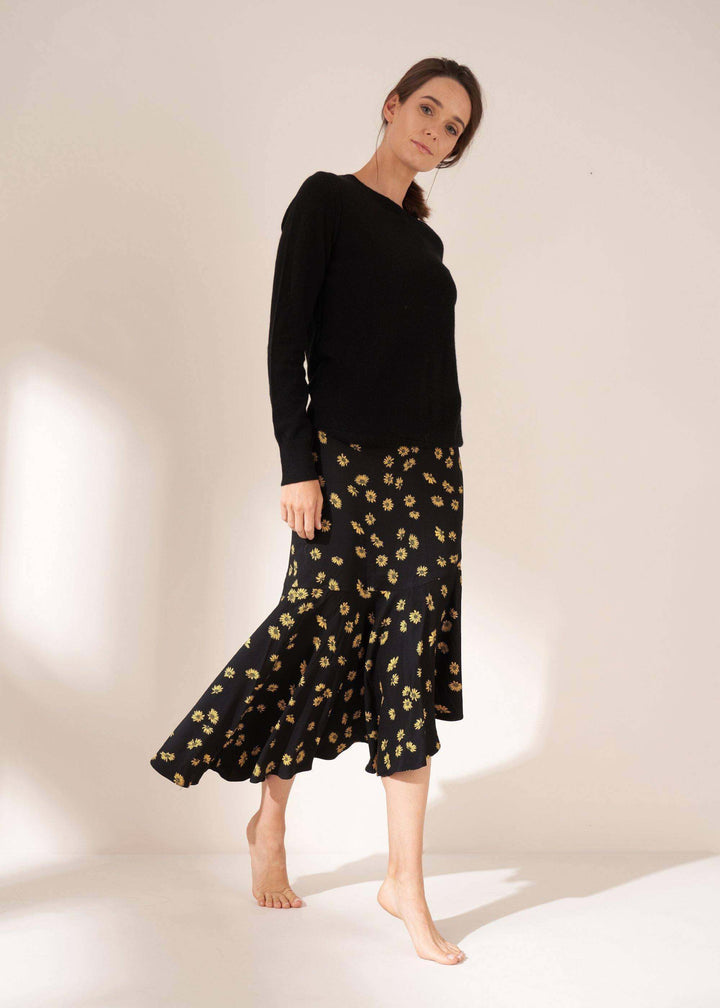 Womens Black Asymmetric Daisy Print Midi Skirt On Model In Black Cashmere Jumper| Truly Lifestyle